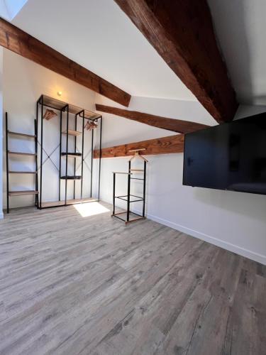an empty room with wooden floors and exposed beams at Beau T3 au cœur du centre ville in Narbonne