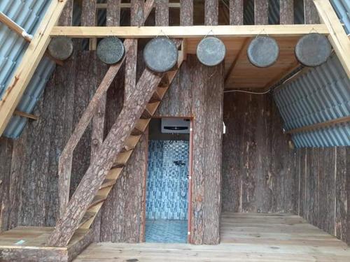 a wooden house with a wooden staircase and a door at Homestay Da Blah in Da Ðeum (2)