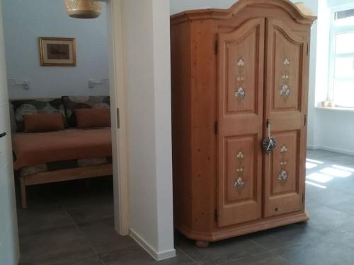 a wooden cabinet next to a room with a couch at Lovely apartment in the city center in Pula