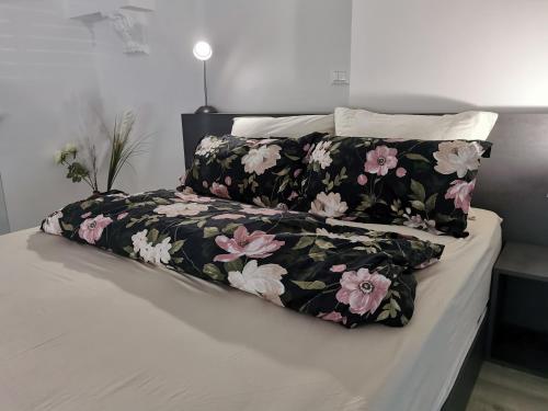 a bed with a black and pink floral blanket at DREAMY CENTER LOCATION in Ljubljana