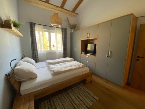 a small bedroom with a bed and a television at Moderne Kaminstube in Ramsau am Dachstein