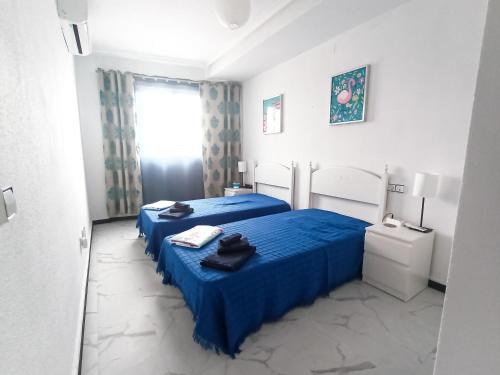 a hotel room with two beds and a window at TORRE La MATA Apartamento in La Mata