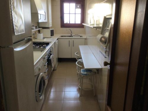 uma cozinha com um lavatório e um fogão forno superior em Apartamento Mirador De La Darsena em Port Saplaya