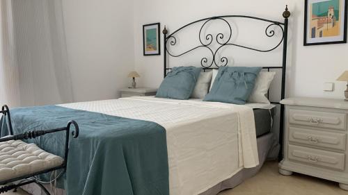 1 dormitorio con 1 cama grande con almohadas azules en Espectacular apartamento primera linea de playa - Golf en Estepona