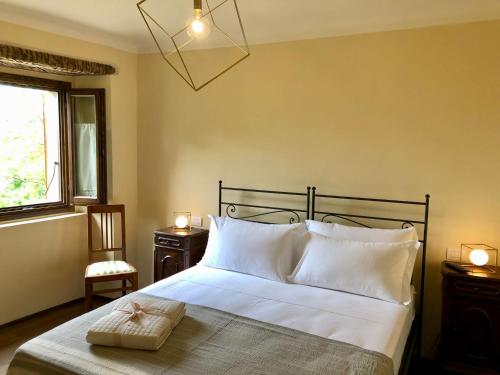 - une chambre avec un lit doté d'oreillers blancs et d'une fenêtre dans l'établissement Podere Fabbrani, à Pennabilli