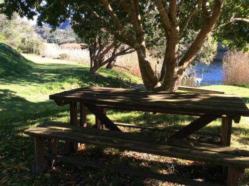 a wooden picnic table sitting next to a tree at Long Thin Farm in Stilbaai