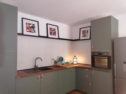 a kitchen with a sink and a stove top oven at Studio cosy aux portes de Bordeaux et Saint Emilion in Yvrac