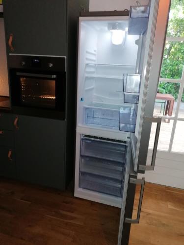 un réfrigérateur vide avec sa porte ouverte dans une cuisine dans l'établissement Studio cosy aux portes de Bordeaux et Saint Emilion, à Yvrac