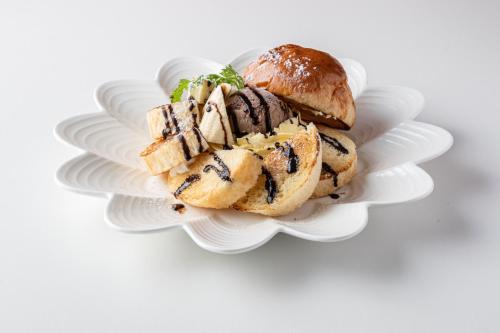 a white plate with a sandwich and a bun at Hotel LOVE JEWEL in Kitakyushu