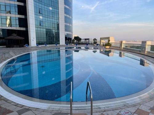 a large swimming pool in front of a building at Cozy Upgraded Residential Flat with sea, Mangrove, pool view - 1203 Not Hotel in Abu Dhabi