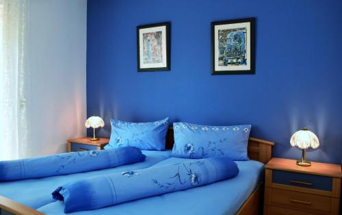 two beds in a room with blue walls at Ferienwohnung Jakobsweg in Dietrichingen