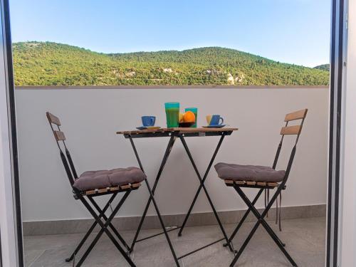 a table and two chairs on a balcony at Apartment Matea in Mokošica