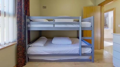 two bunk beds in a room with a bathroom at Harbour View, Mullaghmore, Sligo in Sligo