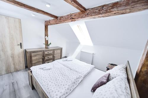 two beds in a bedroom with white walls and wooden beams at U Trautyho in Zadní Chodov