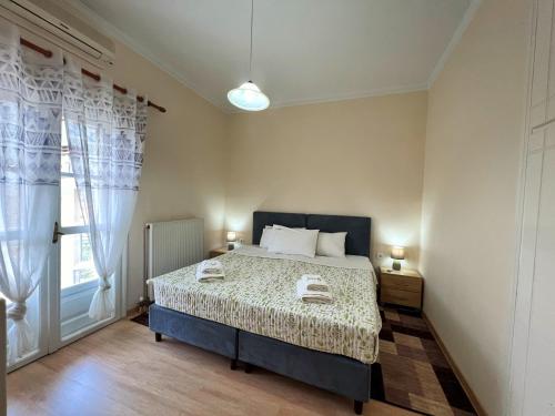 a bedroom with a bed and a large window at Leonidio Apartment Maria in Leonidio