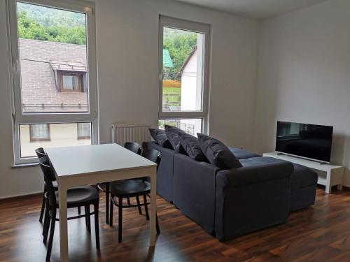 een woonkamer met een bank en een tafel bij Apartma Valan in Bovec