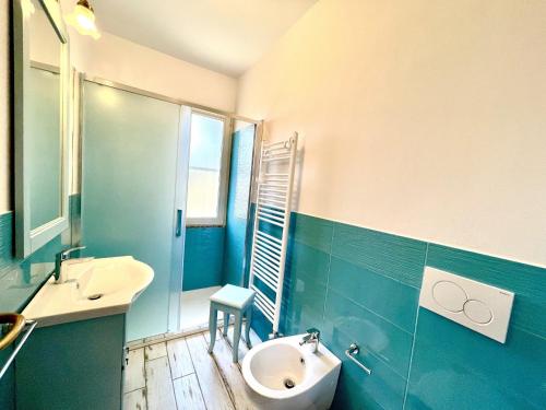 Un baño con lavabo, inodoro y espejo. en Apts. Serena by SolturElba, en Capoliveri