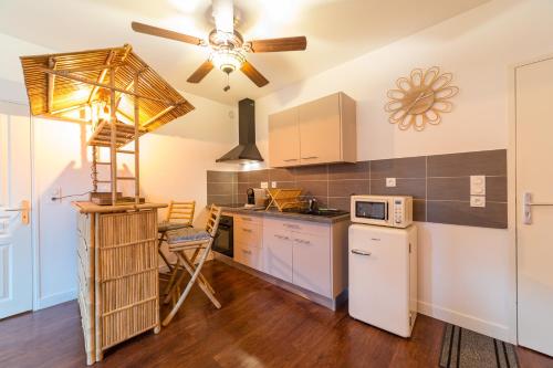 una cucina con elettrodomestici bianchi e un ventilatore a soffitto di Appartement L'Évasion Nature a Troyes