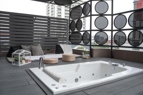 a bath tub in a room with a large window at THEA Private Suites by TH District in Bangkok