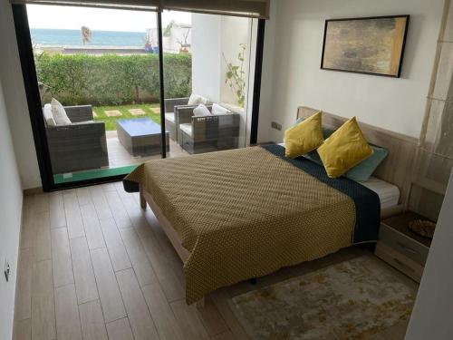 - une chambre avec un lit et une vue sur l'océan dans l'établissement Luxery stay with seaview, pool, green space & Sunset orientation near Rabat, à Sidi Bouqnadel