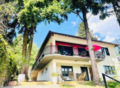 a house with a balcony and trees at La Madeleine in Amplepuis