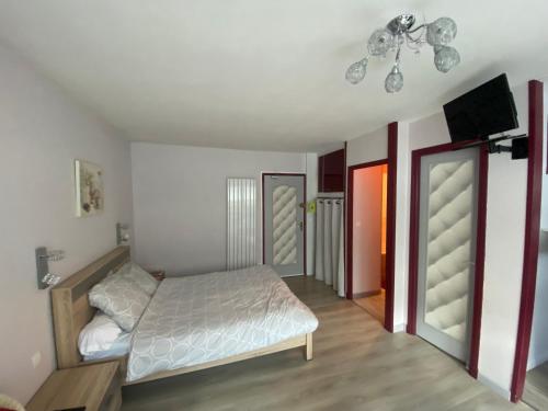 een slaapkamer met een bed en een flatscreen-tv bij Studio avec parking privé au cœur du Tréport in Le Tréport