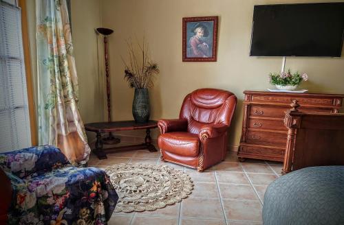 a living room with a chair and a television at Relais de Laval in Caudiès-de-Fenouillèdes