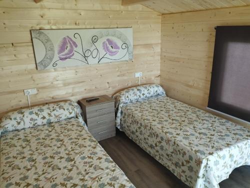 Duas camas num quarto com paredes de madeira em Camping Fraga Balada em Porto do Son