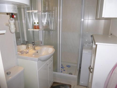 La salle de bains blanche est pourvue d'une douche et d'un lavabo. dans l'établissement Appartement Saint-Hilaire-de-Riez, 2 pièces, 4 personnes - FR-1-224C-27, à Saint-Hilaire-de-Riez
