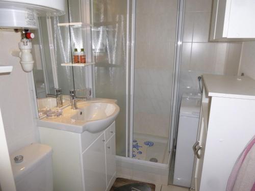 une salle de bain blanche avec une douche et un lavabo dans l'établissement Appartement 2 pièces, balcon vue mer, parking privé, plage des Demoiselles - FR-1-224C-27, à Saint-Hilaire-de-Riez