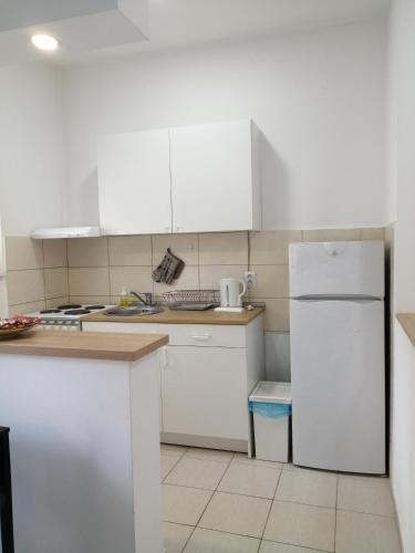 a kitchen with white cabinets and a white refrigerator at Apartment Teodora in Belgrade