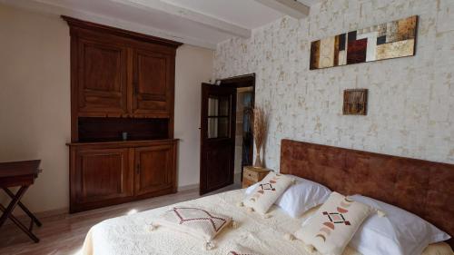 - une chambre avec un lit et une tête de lit en bois dans l'établissement La source du Touron, à Fons