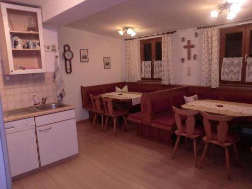 a kitchen and dining room with two tables and a couch at Lehenbrandthof in Leogang