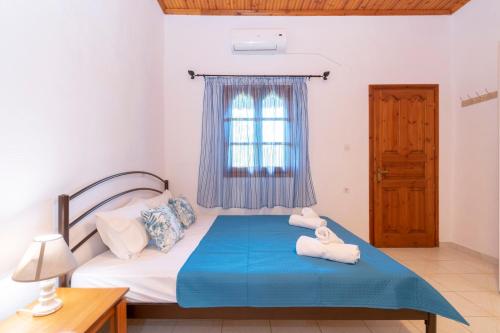 a bedroom with a bed with towels on it at melissi studios in Paralia Sikias