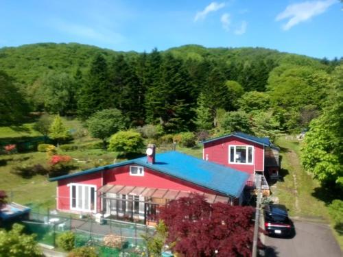 an aerial view of a red house with a blue roof at NOBORIBETSU no MORI in Noboribetsu