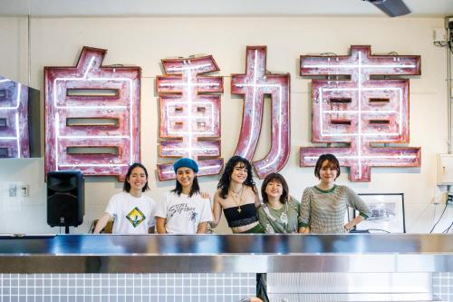 a group of girls standing in front of a counter at Spice Motel Okinawa in Kitanakagusuku