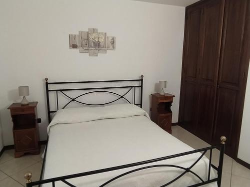 een slaapkamer met een bed en twee nachtkastjes bij Estìa Casa Vacanze in Scilla