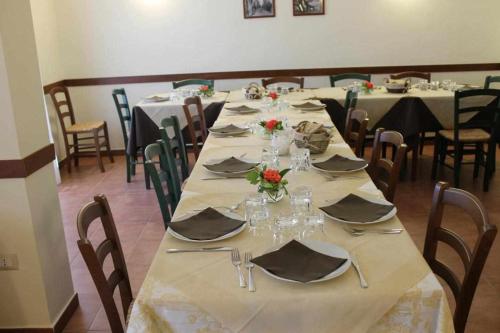 フォッジャにあるLe Anfore di Arpiのテーブルと椅子付きの部屋内の長テーブル