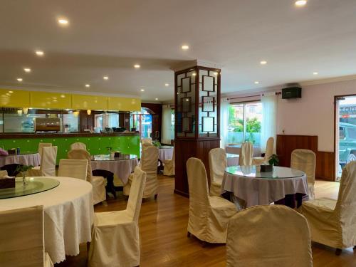 a restaurant with tables and chairs and a kitchen at Chung Hsin Hotel 中信酒店 in Phnom Penh