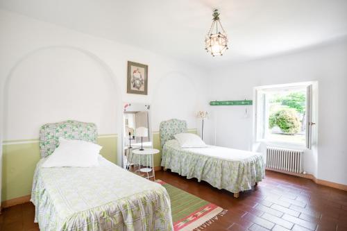 ein Schlafzimmer mit zwei Betten und einem Fenster in der Unterkunft Bright APT surrounded by greenery with parking & Shared Pool in Villa Guardia