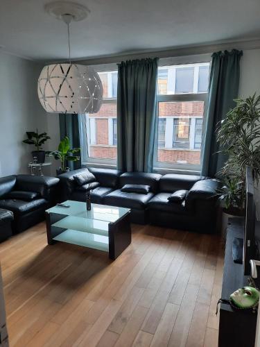 a living room with a black couch and a glass table at Sint Andries Duplex in Antwerp