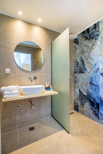 a bathroom with a sink and a mirror at Alia Comfort Style Studios in Limenaria