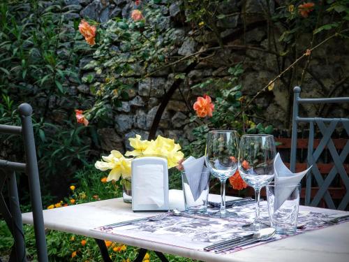 - une table avec des verres à vin et des fleurs dans l'établissement Relais de Laval, à Caudiès-de-Fenouillèdes