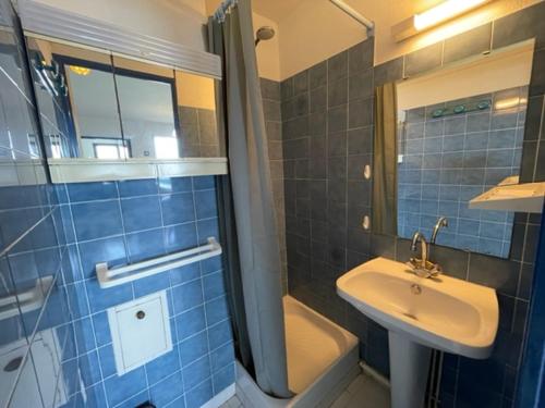 une salle de bain carrelée bleue avec un lavabo et une douche dans l'établissement Appartement avec piscine commune à 800 m Plage 5RH1155, à Saint Pierre La Mer