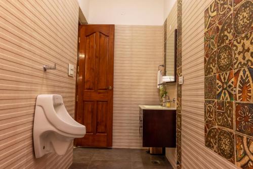 a bathroom with a urinal and a sink at Kunwar Villa in Amritsar