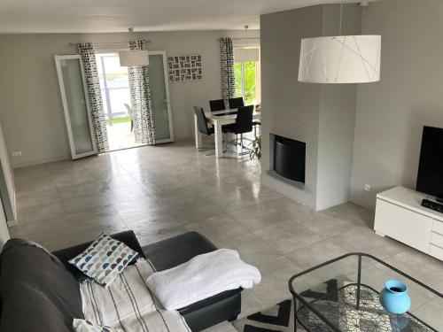 a living room with a couch and a table at Maison familiale avec jardin de 1500m2 in Saint-Genès-de-Fronsac