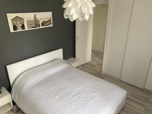 a bedroom with a bed and a chandelier at Maison familiale avec jardin de 1500m2 in Saint-Genès-de-Fronsac