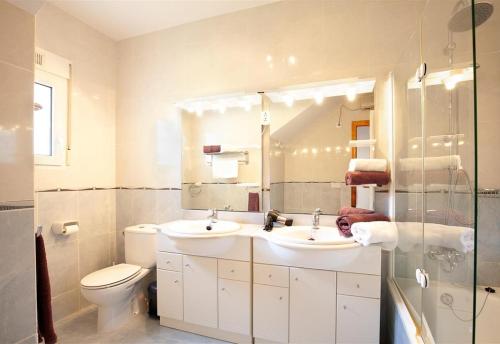 uma casa de banho com 2 lavatórios, um WC e um espelho. em Nice villa beautiful view em Pedreguer