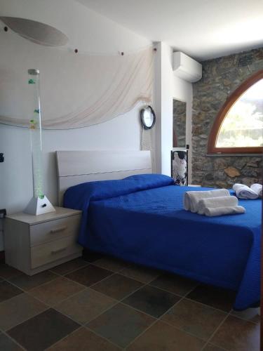 a bedroom with two beds with blue sheets and a window at Elios bed and breakfast in Villa - Fuscaldo in Pietrapiana