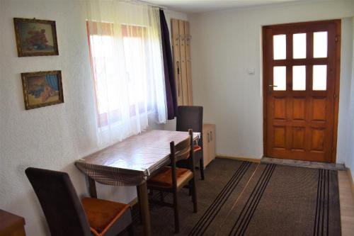 Habitación con una puerta y una mesa y sillas de madera. en Šepić Accommodation, en Žabljak